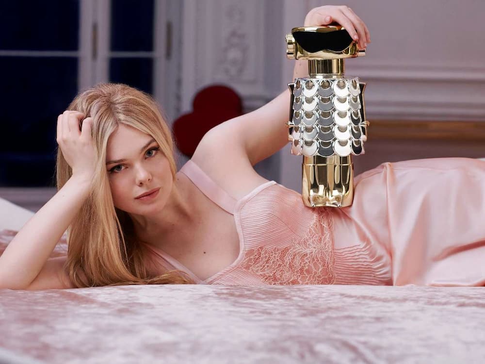 a woman lying on a bed holding a gold robot